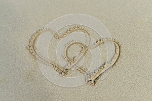 Two hearts drawn in sand