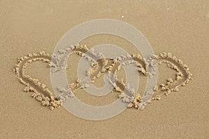 Two hearts drawn in the sand on the beach