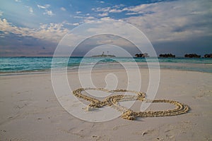 Two hearts drawn in the sand at the tropical beach