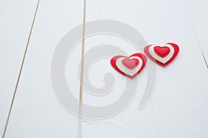 Two hearts hanging on white painted wooden background