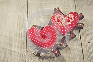 Two hearts hanging on wooden background