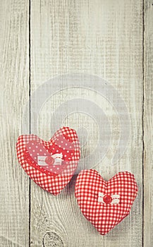 Two hearts hanging on wooden background