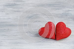 Two hearts of love close-up on a light gray wooden background.