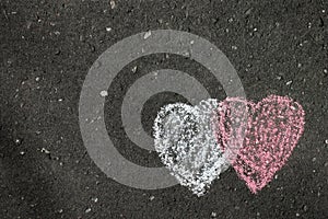 Two hearts painted on grey asphalt