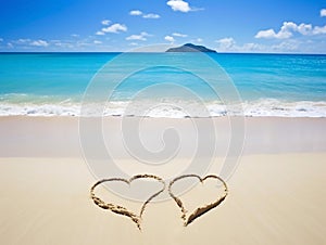 Two hearts on a sandy beach, against a beautiful blue sea with waves and a sky with clouds