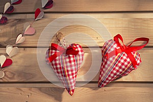 Two hearts sewn from red plaid fabric on the board,