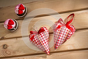 Two hearts sewn from red plaid fabric on the board