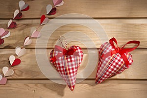 Two hearts sewn from red plaid fabric on the board