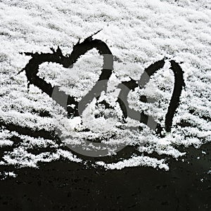 Two hearts, symbol of love, hand drawn on snow covered windshield of car. Valentine's Day, love, winter, concept