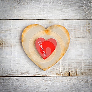 Two hearts with the text I love you on a wooden background