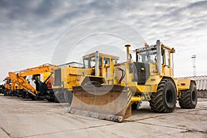 Two heavy wheeled tractor one excavator and other construction machinery
