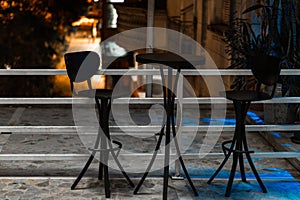 Two hig black stools and a table