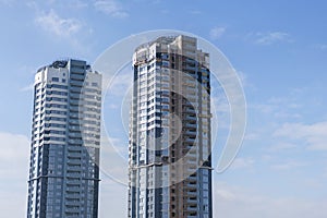 Two high-rise buildings on a blue sky background