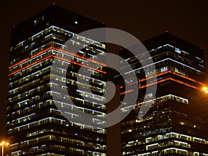 Two high-rise buildings connected by a transition in the night city