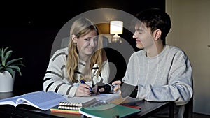 Two high school students, a boy and a girl, prepare for college lectures together. Teenagers are having fun. First love.