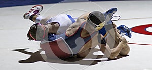 Two high school wrestlers grapling during a match