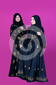 Two hijab muslim woman on pink background