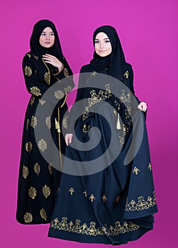 Two hijab muslim woman on pink background