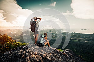 Two hikers relax on top of a mountain