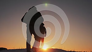 Two hikers tourists walking go on sunset top met on top of a mountain silhouette winter. teamwork travel business