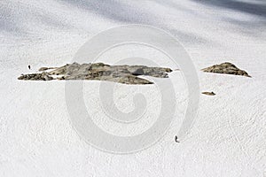 Two hikers walking across a vast ice field on top of a mouintain in British Columbia