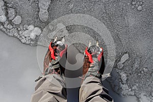 Two hiking boots with crampons on the ice. Mountain sport accessories concept