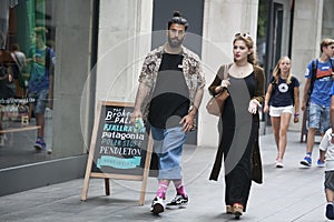Two hipster girls dressed in cool Londoner style walking in Brick lane, a street popular among young trendy people