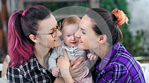 Two hipster informal careful mother feeling love kissing and hugging little son medium close-up