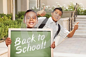 Two Hispanic Boys Giving Thumbs Up Holding Back to School Chalk Board