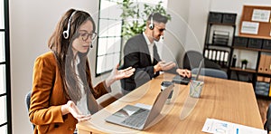 Two hispanic call center agents working at the office