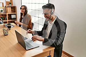Two hispanic call center agents working at the office