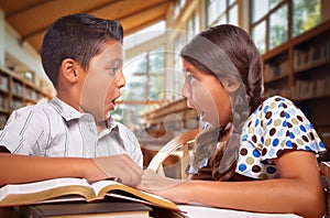Two Hispanic School Kids in a Library with a Shocked Expression on Their Faces