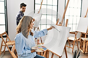 Two hispanic students painting at art school