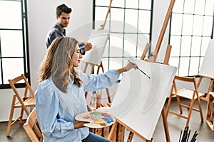 Two hispanic students painting at art school