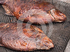Two homemade smoked bream on a metal mesh