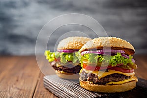 Two homemade tasty burgers on wooden table