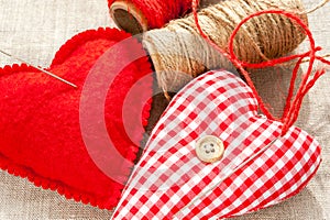 Two homemade textile sewed red cotton love hearts. Closeup.