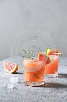 Two honey rosemary grapefruit sodas on light grey. photo