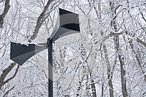 Two horns of a black outdoor loudspeaker in a retro style on the background of a snowy park