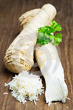 Two horseradish roots on a wooden board