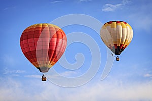 Two hot air balloons against a blue sky