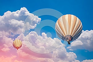 Two hot air balloons with cloudy blue sky background
