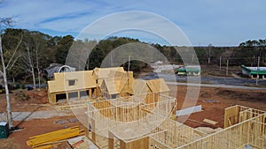 Two houses under construction with building envelope and wooden frame beam, joist, trusses framework, gable roof in suburban area