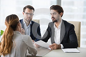 Two hr managers looking with disbelief at female applicant.