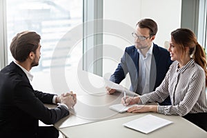 Two hr managers talking with candidate for vacancy.