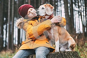 Two huging best friends portrait - boy and his beagle dog sit on