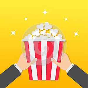 Two human businessman hands holding popcorn box. Movie Cinema icon in flat design style. Pop corn. Yellow gradient background. Shi