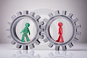 Two Human Figures Walking In Interlocked Gears photo