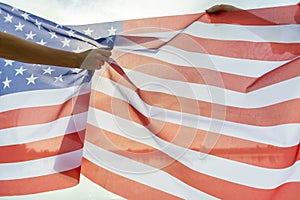 Two human hands holding USA national flag. Celebration of United States independence day concept