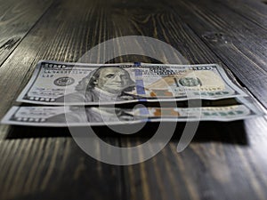 Two hundred dollars bills on a wooden background. new hundred dollar bill. Close up american dollar banknotes